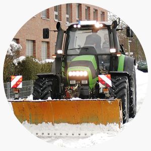 Ein Trecker mit Schneeschild beim Winterdienst in Niedersachsen